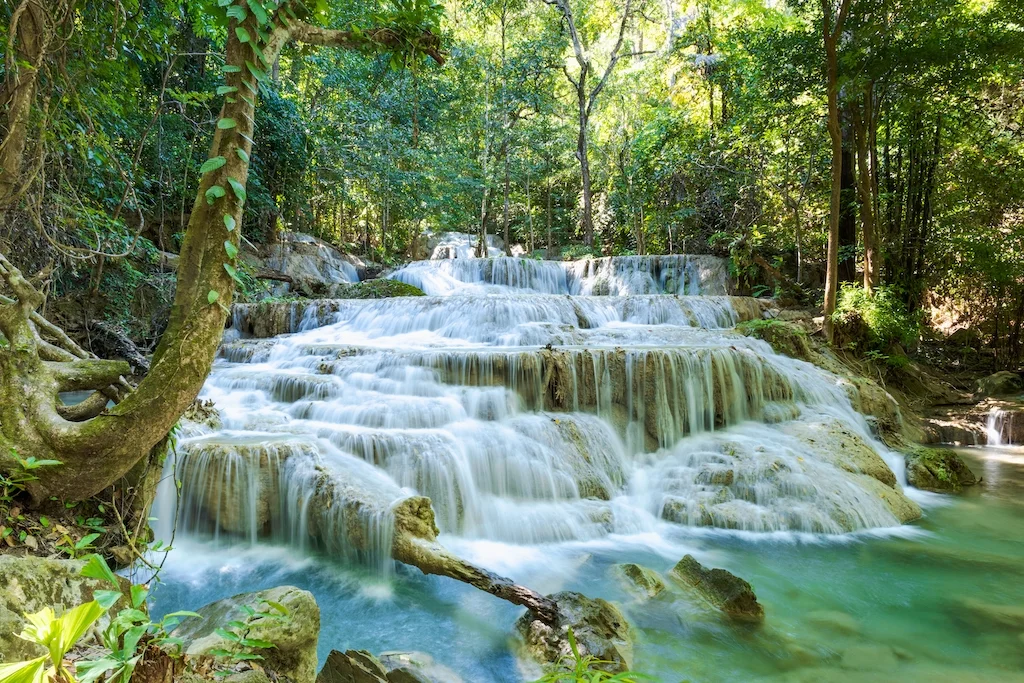 erawan-waterfall-th-floor-with-water-flowing-through-natural-stone-in-tropical-rainforest